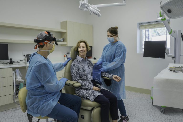 Patient receiving dental checkup in modern clinic with two professionals in Brunswick, Georgia.